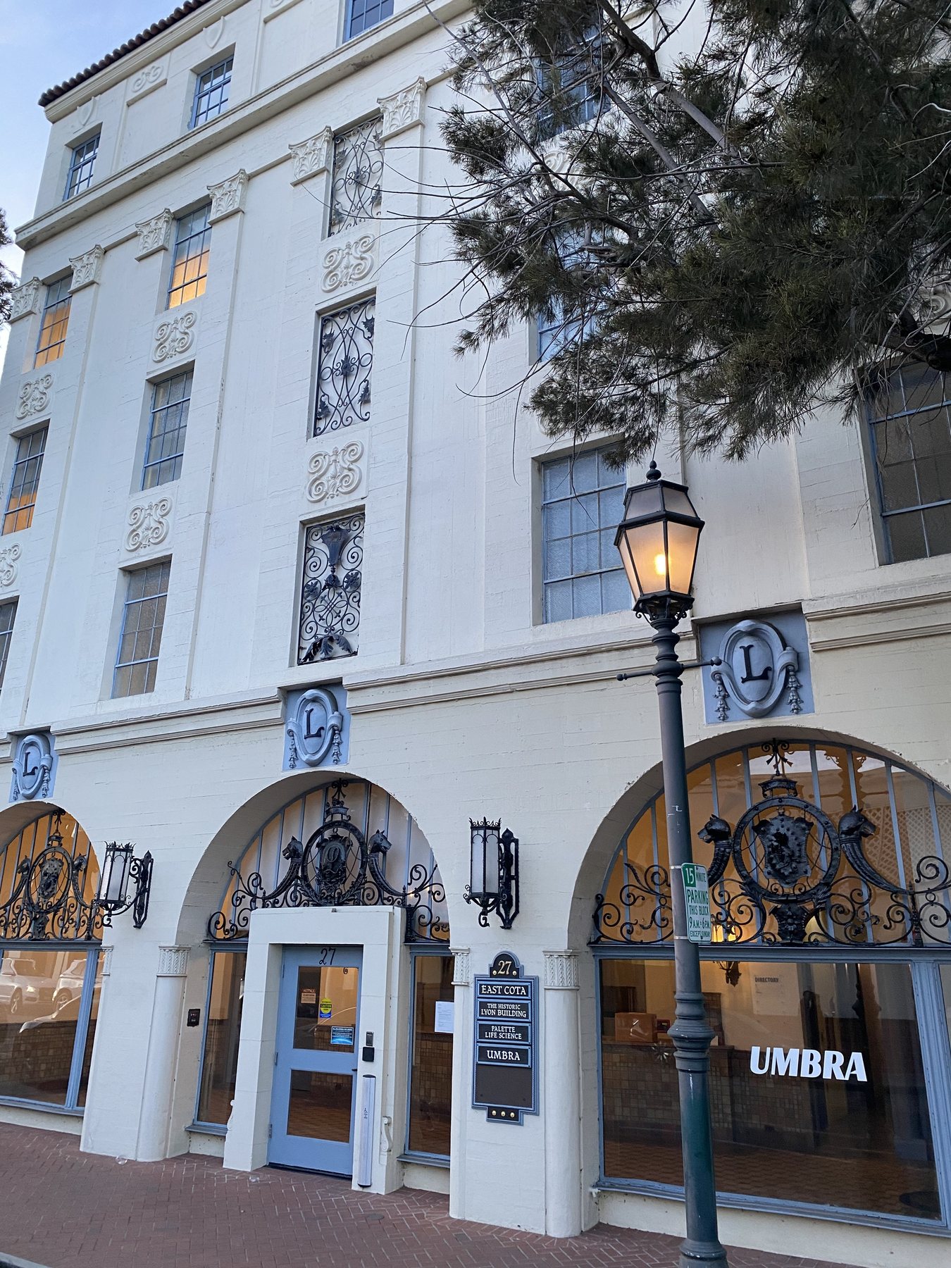 The Lyon Building on East Cota Street: a white Spanish Colonial Revival elevation with arched openings, ornate wrought-iron grilles and a street lantern.