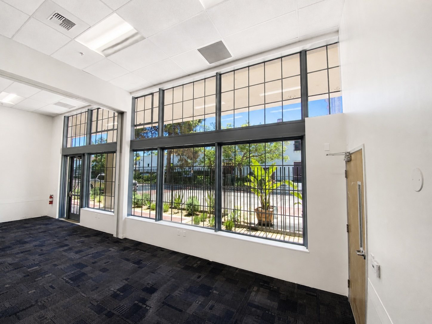 Interior room with steel-framed windows, carpet tile and a folding partition.