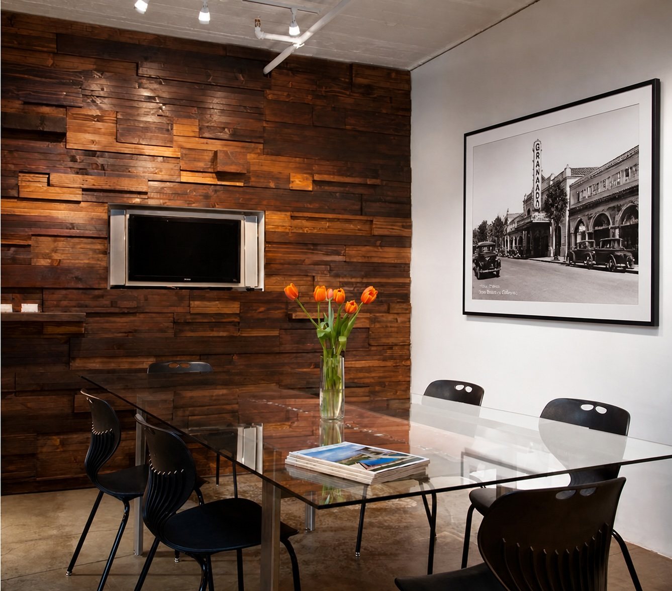 Penthouse conference room with a glass table against a reclaimed timber wall, beside a framed historic photograph of State Street.